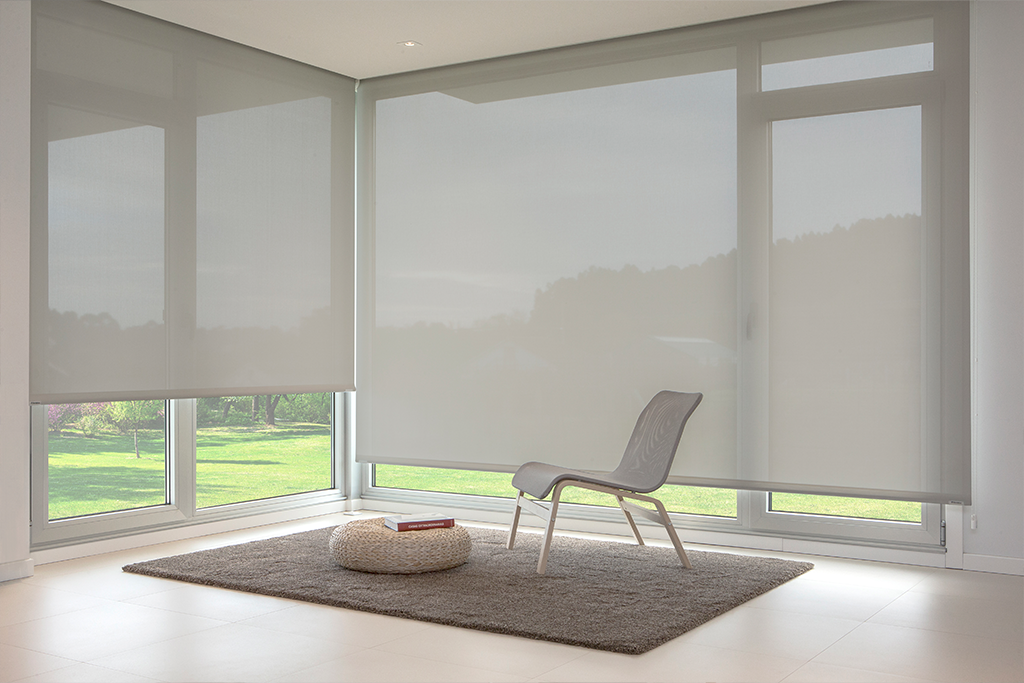 Grey polyscreen roller shade installed in a modern bedroom